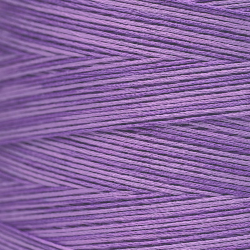 A close-up of lavender purple yarn wound in a herringbone pattern, showing the texture of the individual threads.