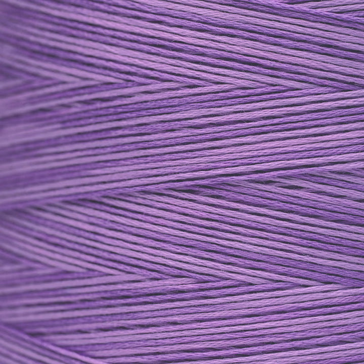 A close-up of lavender purple yarn wound in a herringbone pattern, showing the texture of the individual threads.