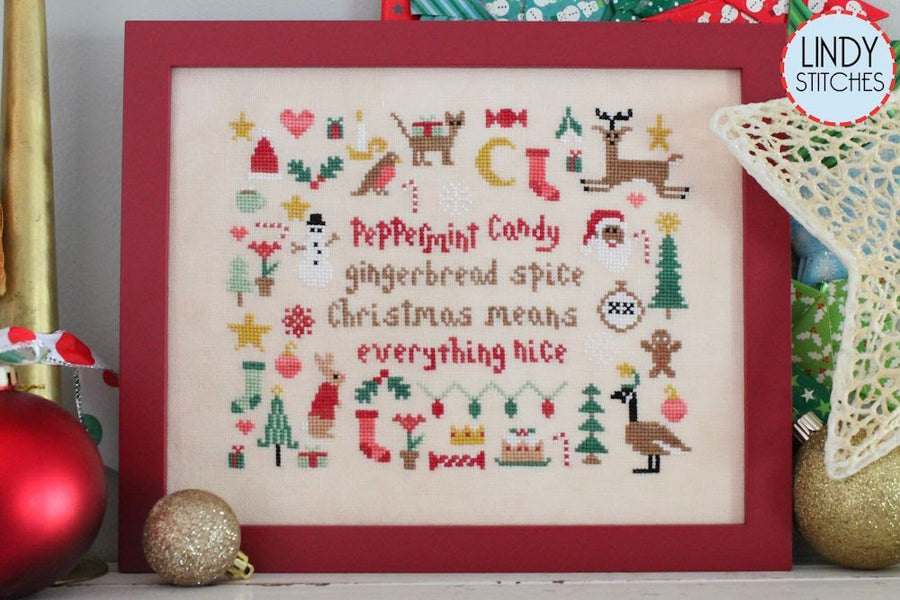 Framed cross-stitch pattern with Christmas-themed designs and text.