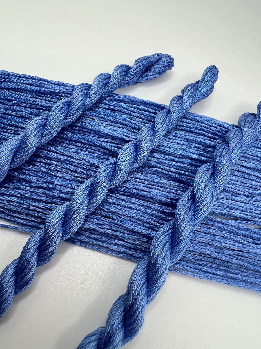Close-up of blue braided yarn on a white background