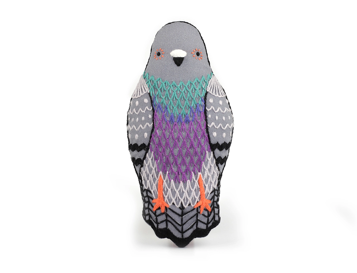 Knitted penguin toy with a patterned design on a white background