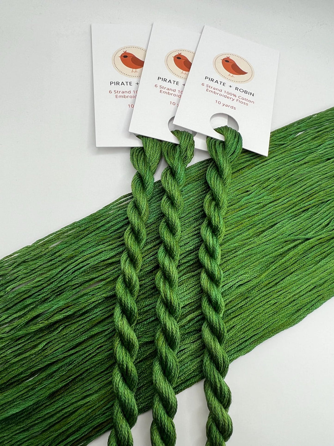 Green thread skeins on a white background