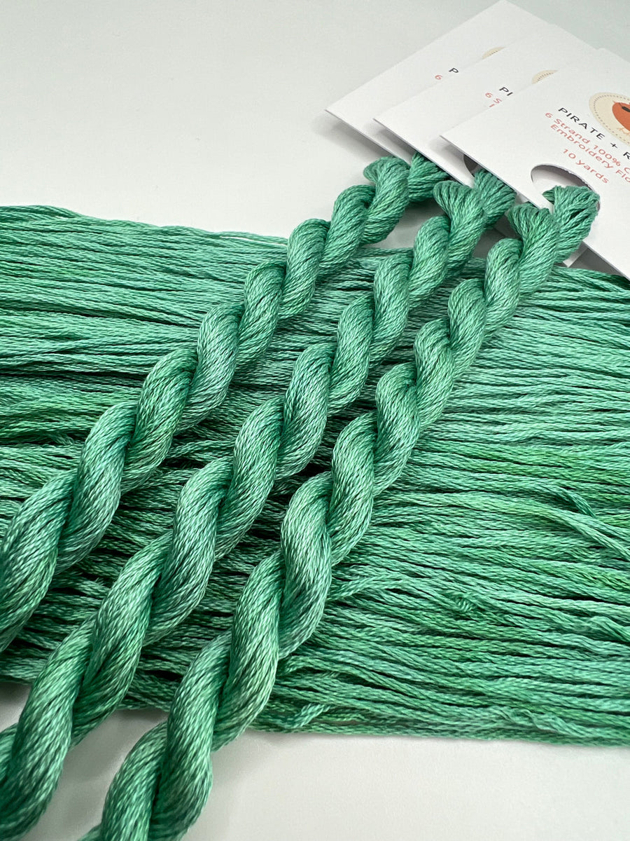 Green embroidery floss on a white background