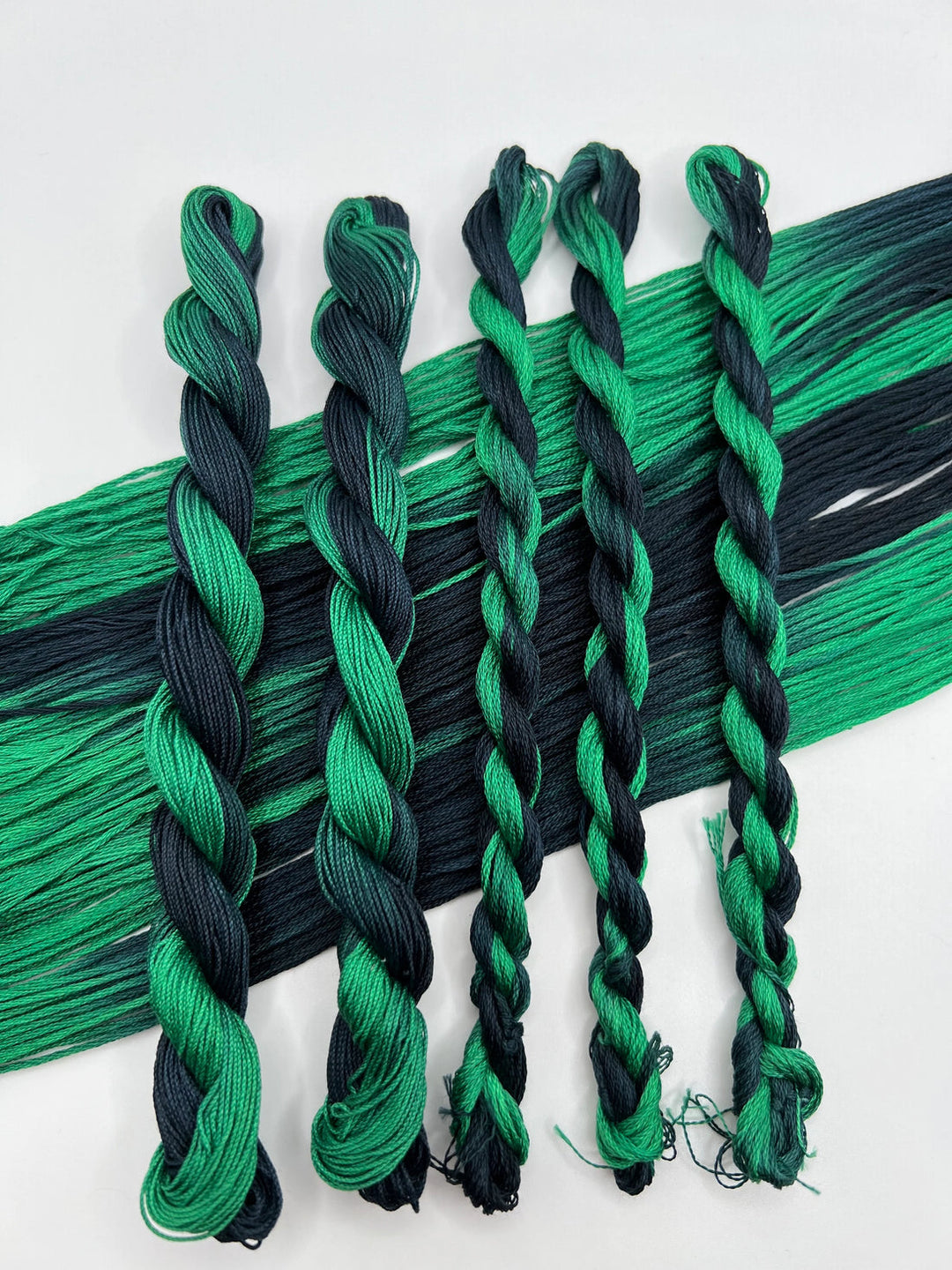 Green and black braided yarn on a white background