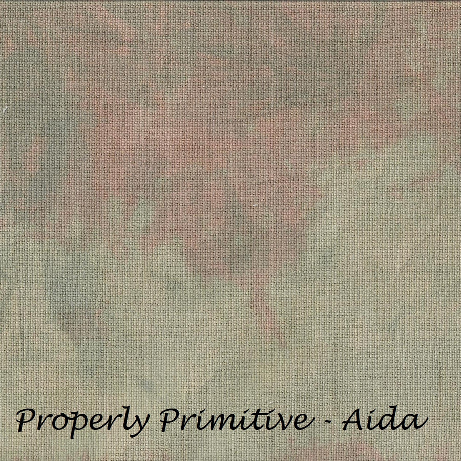 A square fabric or material swatch with a mottled, textured pattern in muted gray-green, dusty pink, and beige tones, with the text 'Properly Primitive - Aida' printed in black at the bottom.