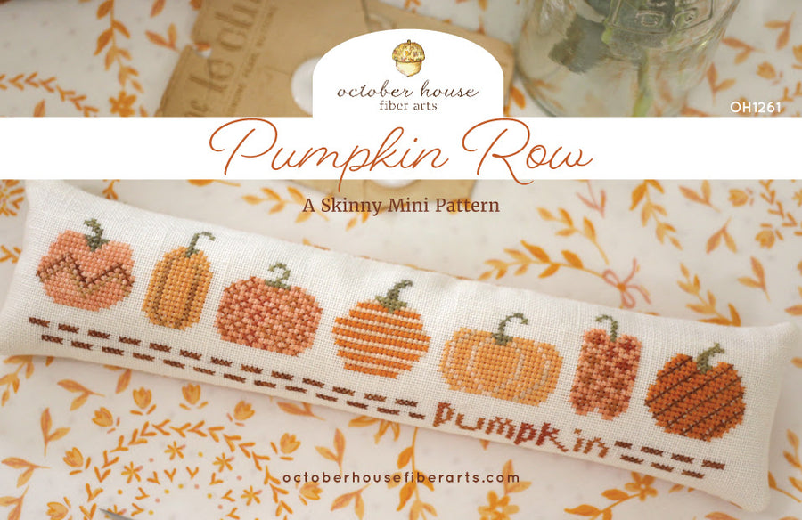 Cross-stitched pumpkin pattern on fabric with 'October House Fiber Arts' branding.