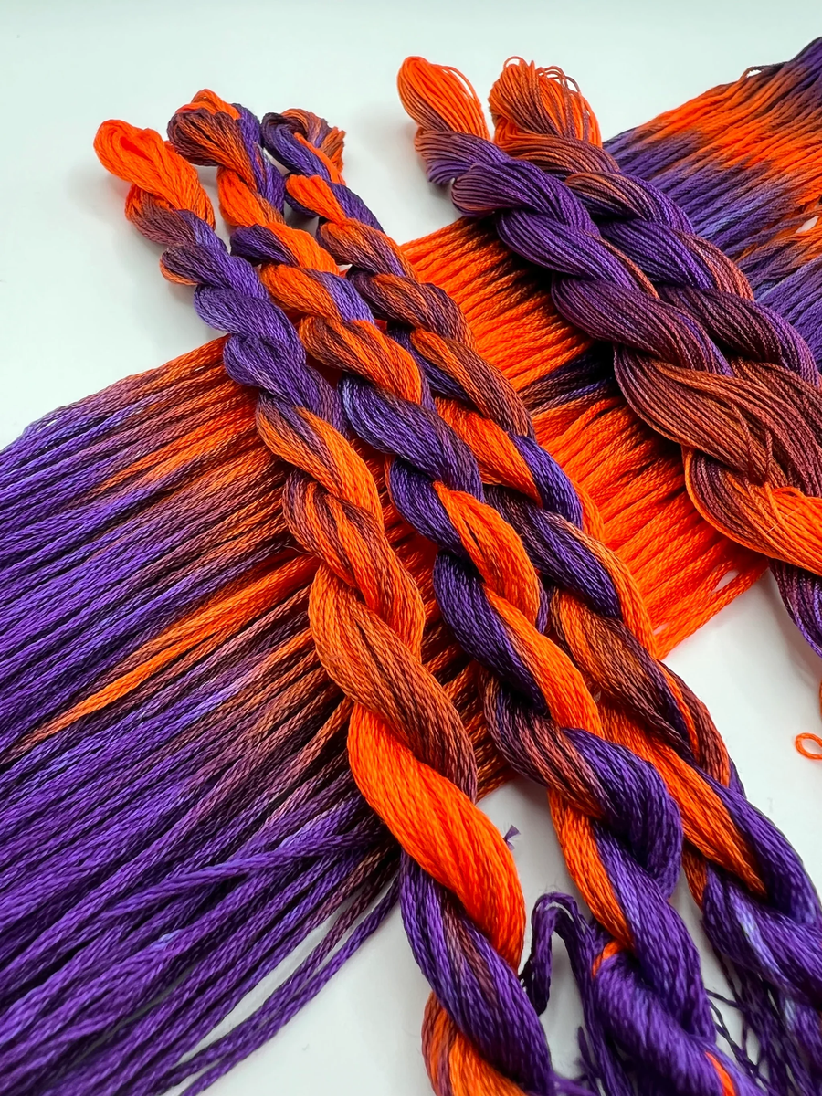 twisted strands of orange and purple thread on a white background