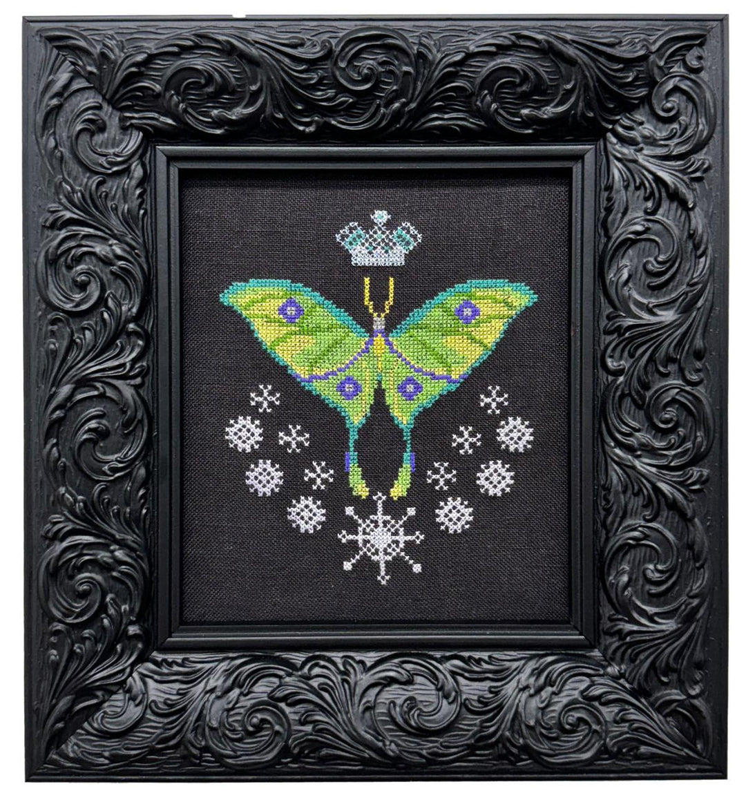 Embroidered butterfly design on black fabric with decorative black frame