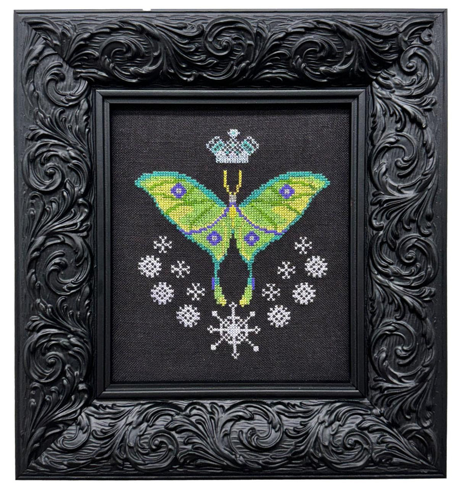 Embroidered butterfly design on black fabric with decorative black frame