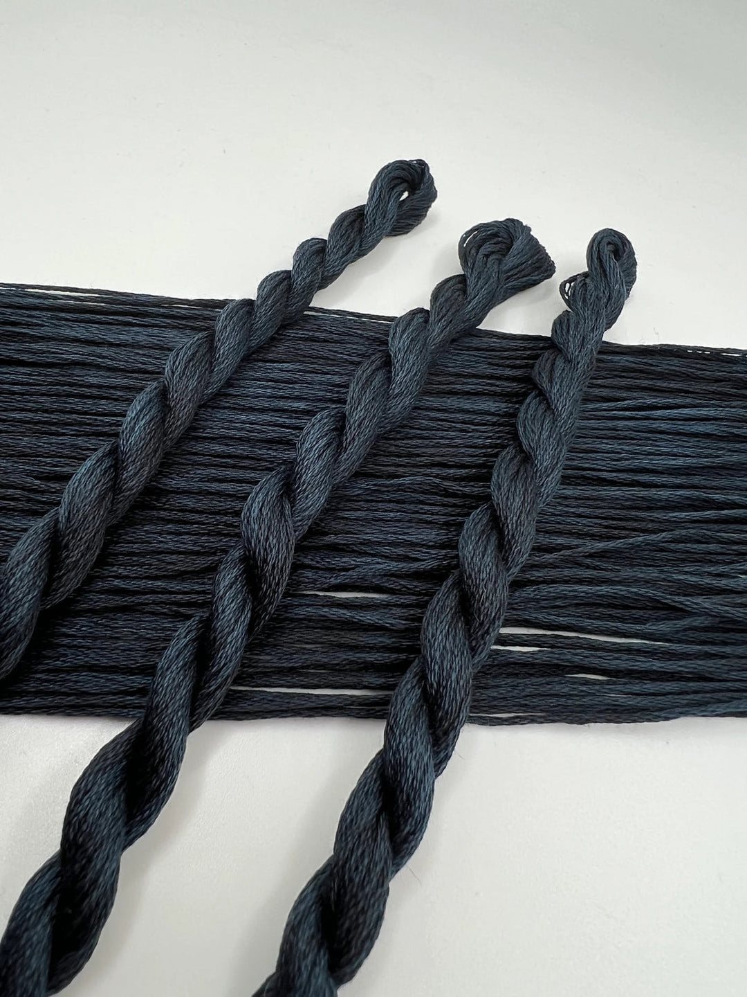 Dark blue braided thread on a white background