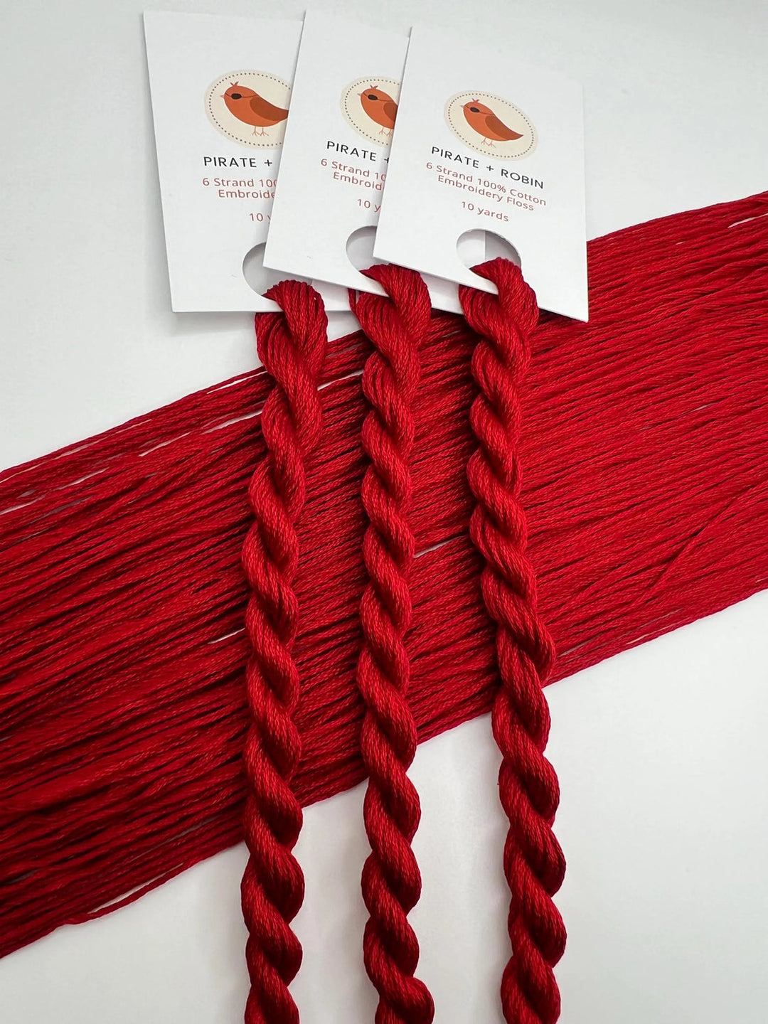 Red yarn with tags on a white background