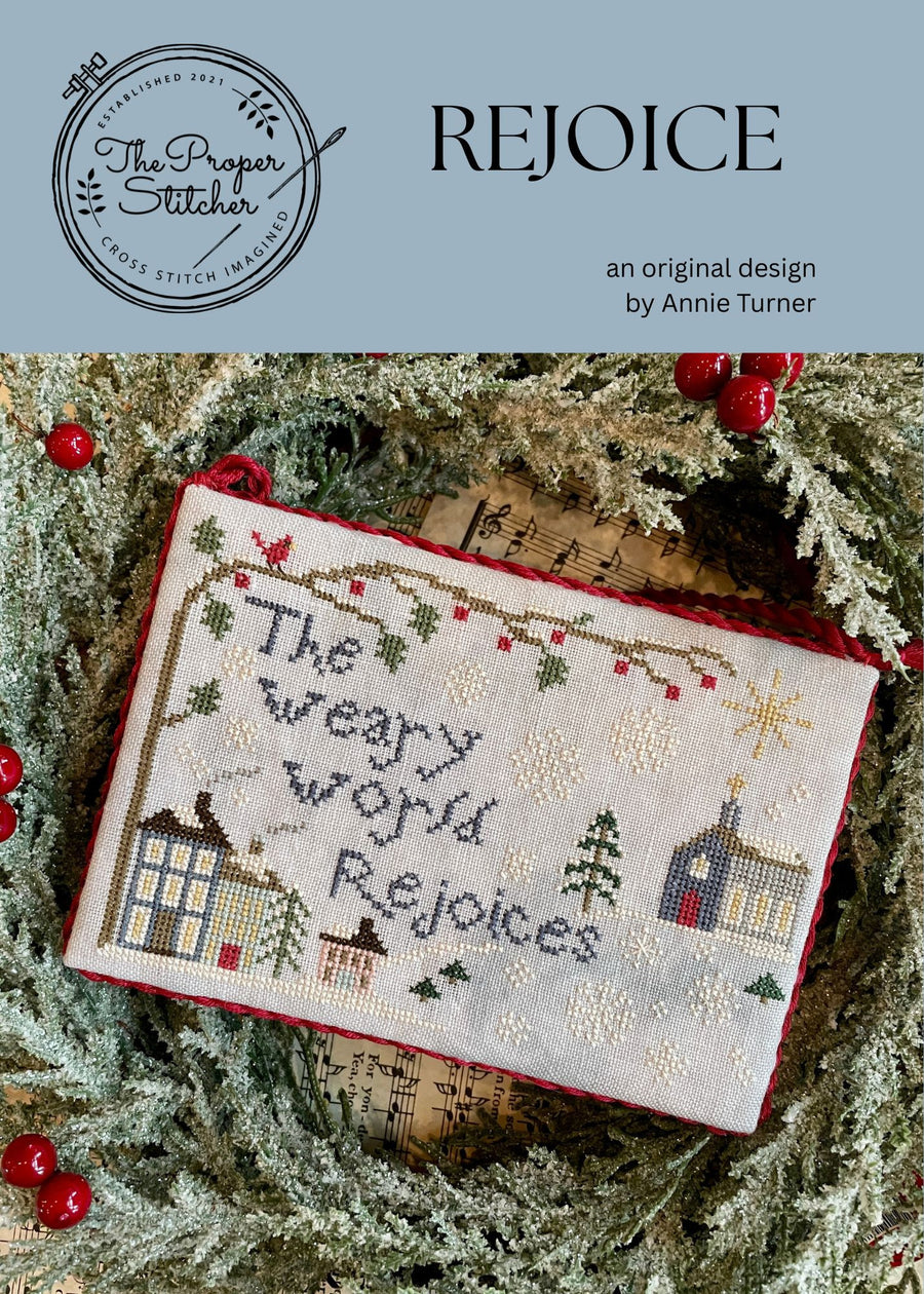 winter design featuring houses, snowflakes, trees and text reading the weary world rejoices