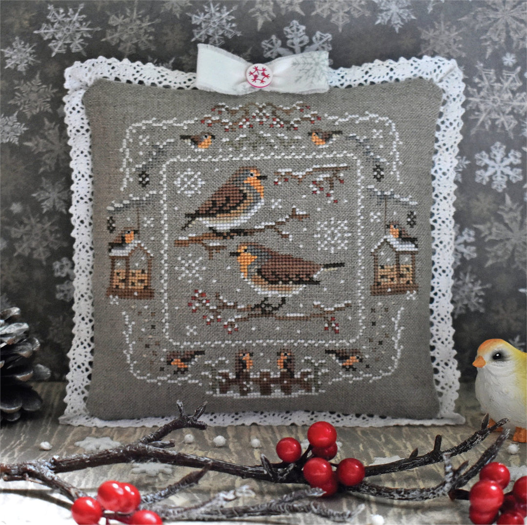 Decorative pillow with bird and berry design on a textured background
