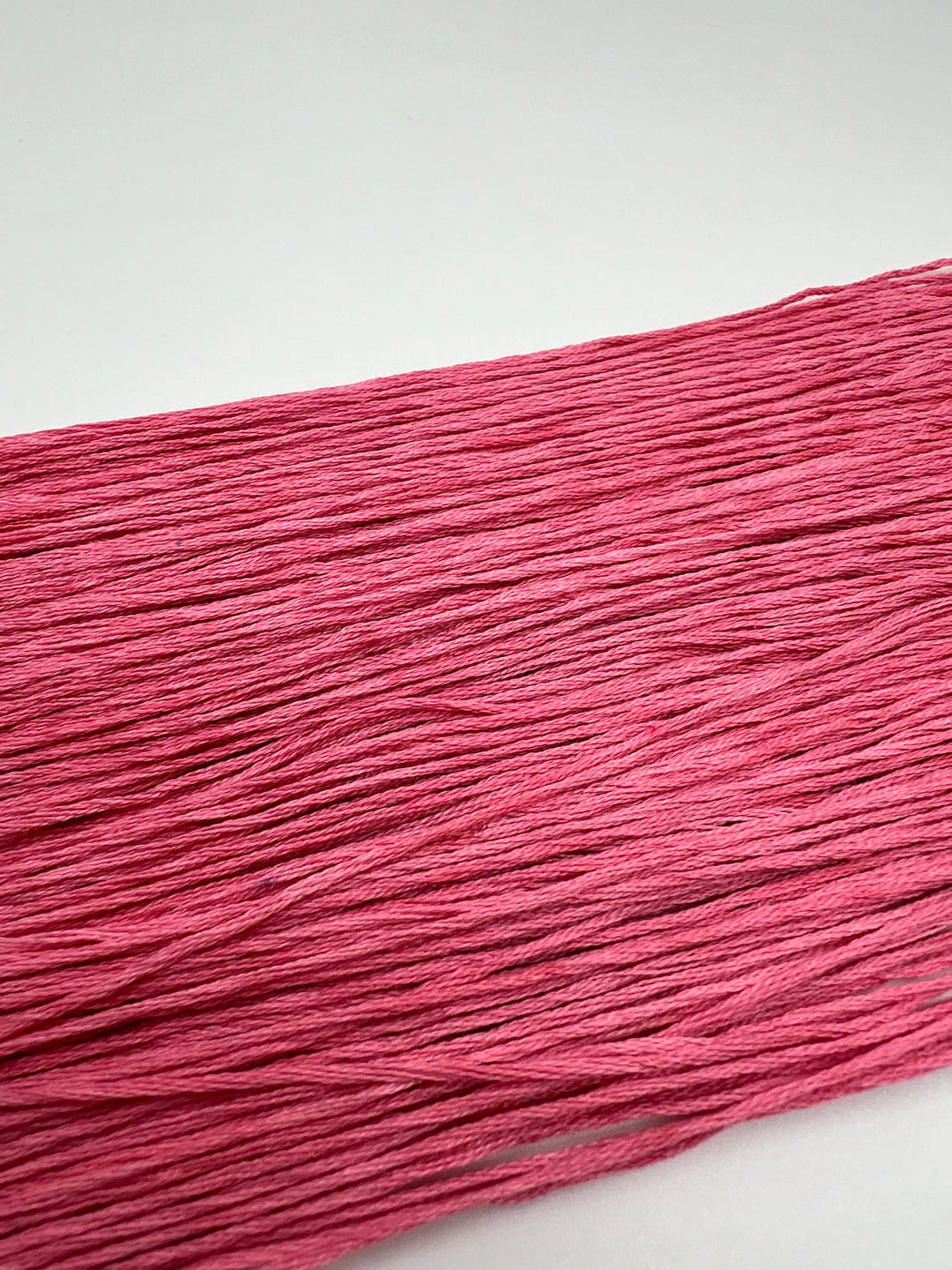 Close-up of pink yarn on a white background