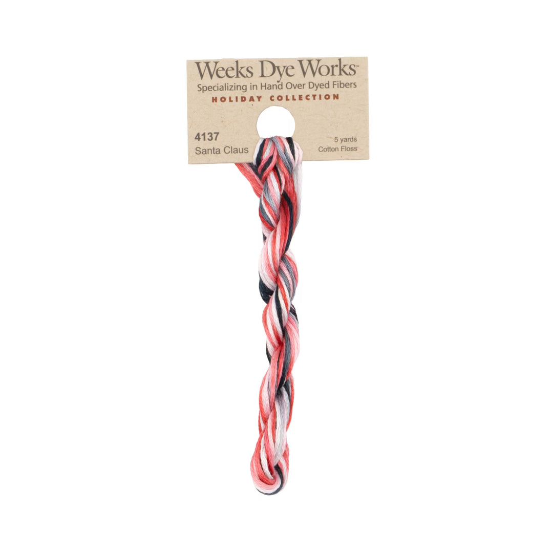 A twisted bundle of Weeks Dye Works Santa Claus holiday collection cotton fibers, featuring red, black, and white strands, attached to a kraft paper label on a white background.