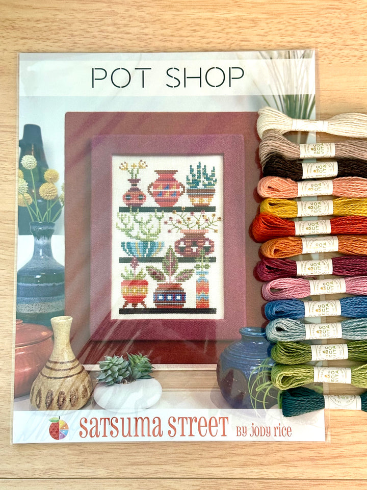 Cross-stitch pattern with pottery and yarn on a wooden surface, featuring 'Satsuma Street' branding.