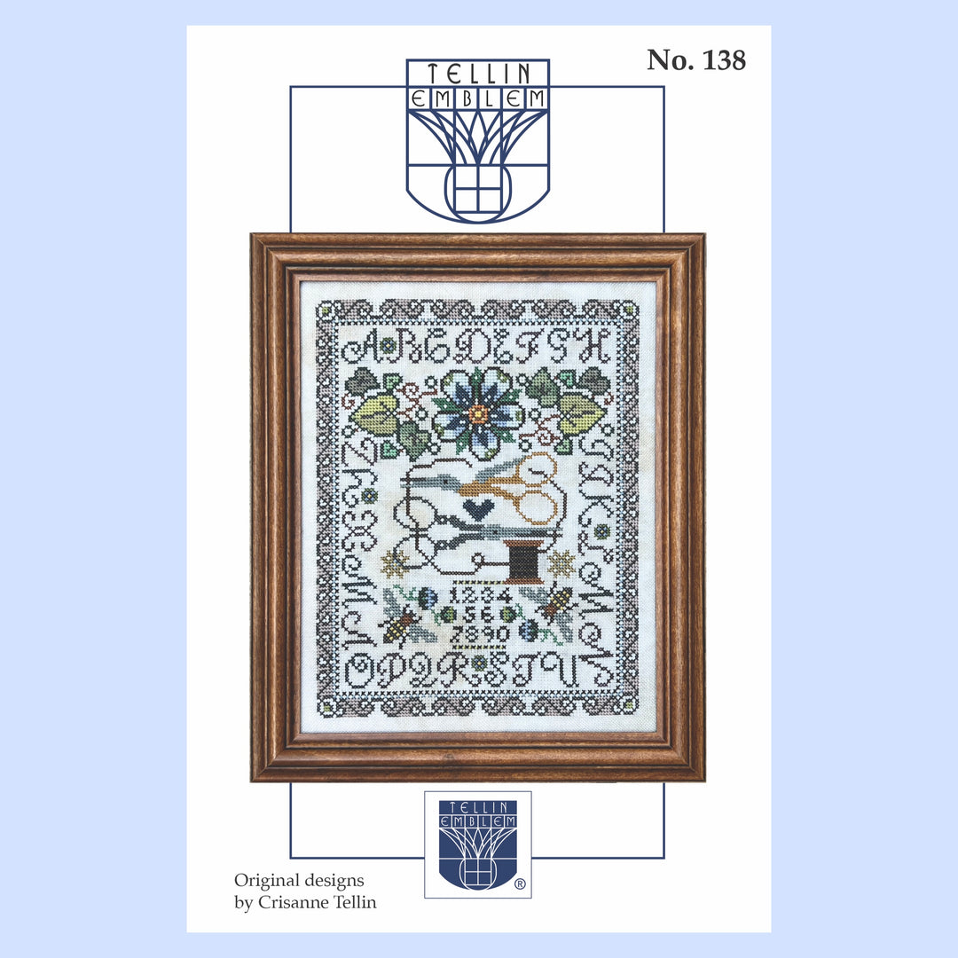 Framed cross-stitch design with decorative elements on a light blue background, featuring the Tellin emblem.