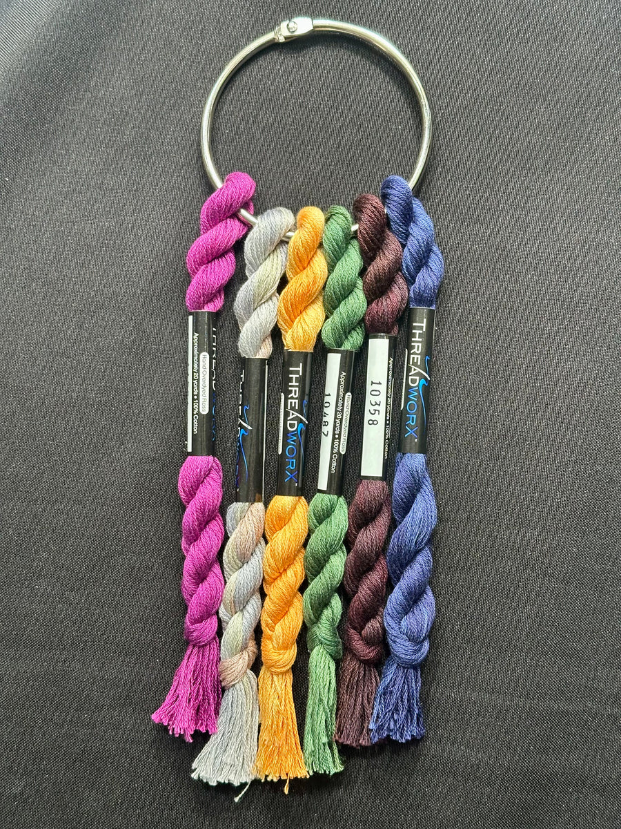 A set of 6 ThreadworX floss colors displayed on a keychain, with each skein arranged in a vertical line to showcase the different colors.
