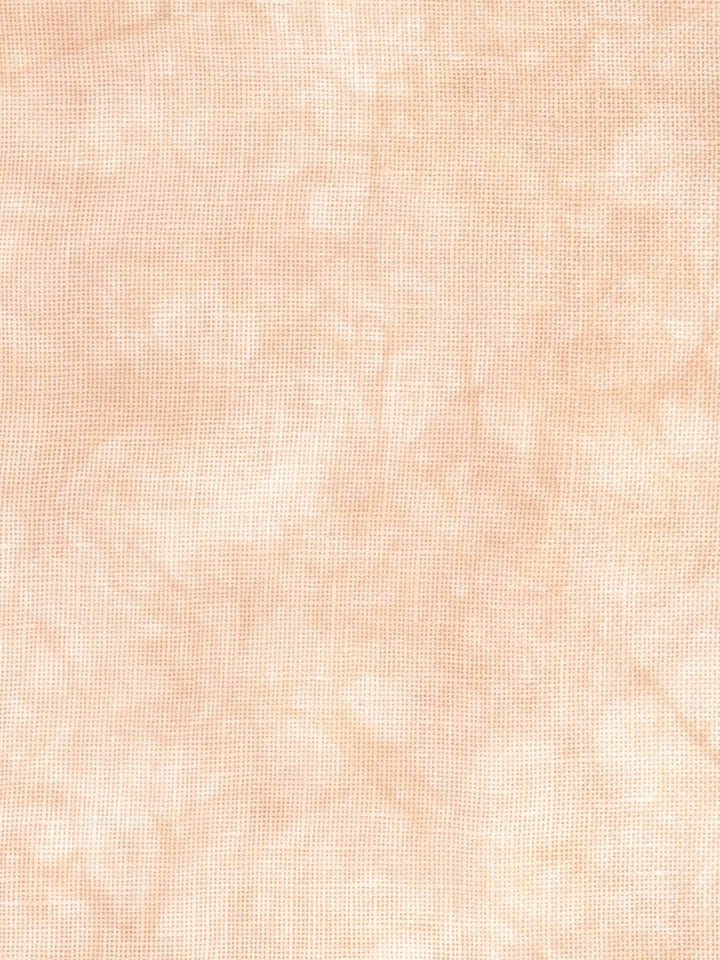 A close-up of a light peach-beige textured fabric with a subtle woven or linen-like pattern.