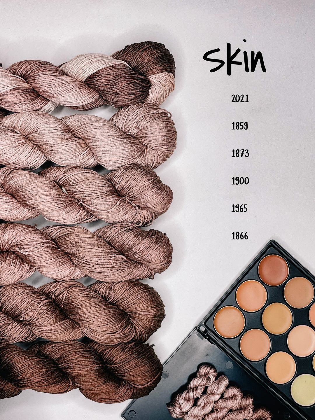 Multiple skeins of beige and brown thread arranged in parallel on a surface, representing the Skin Tone Collection.