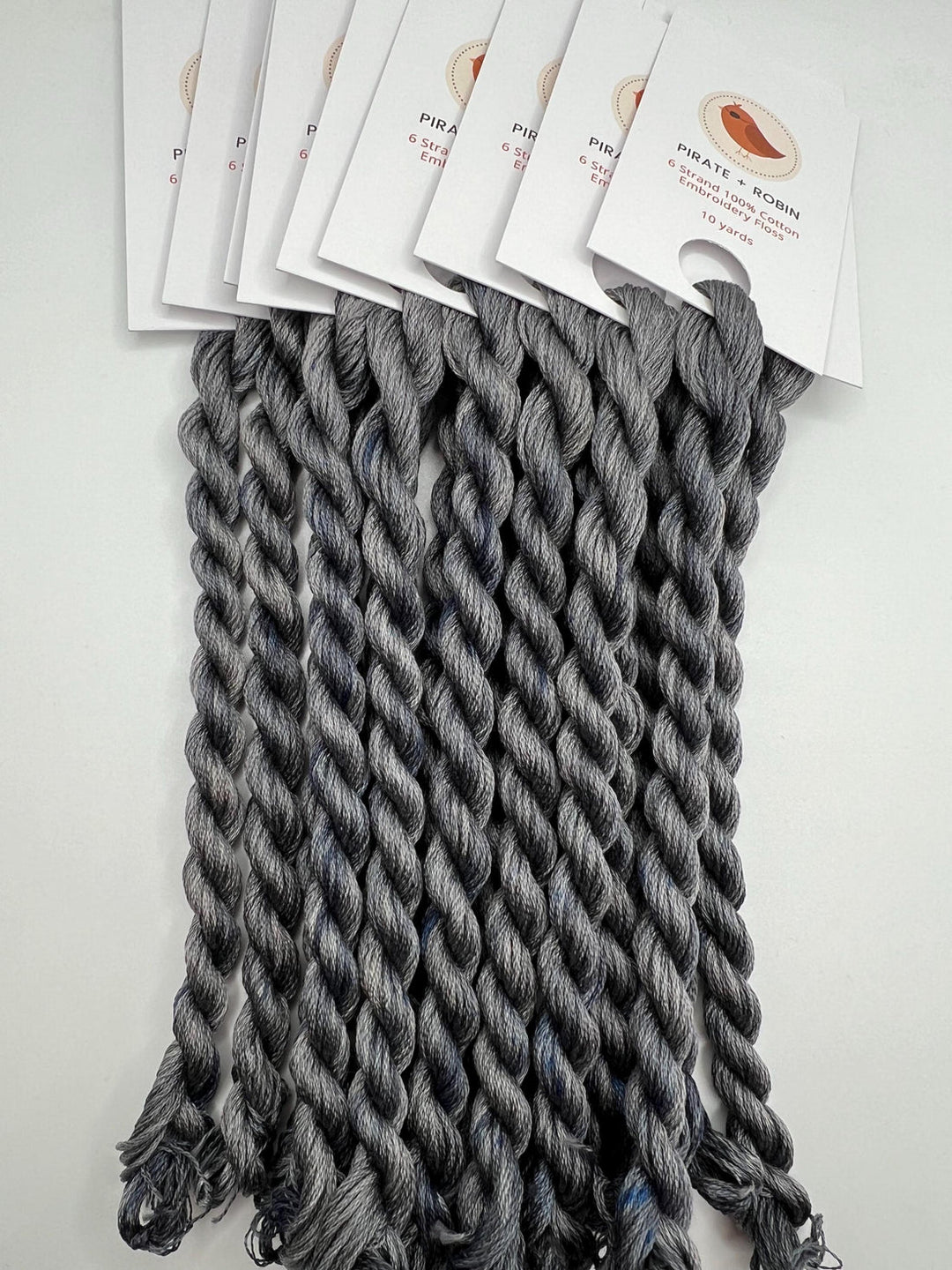 Gray braided hair extensions with branded cards on a white background