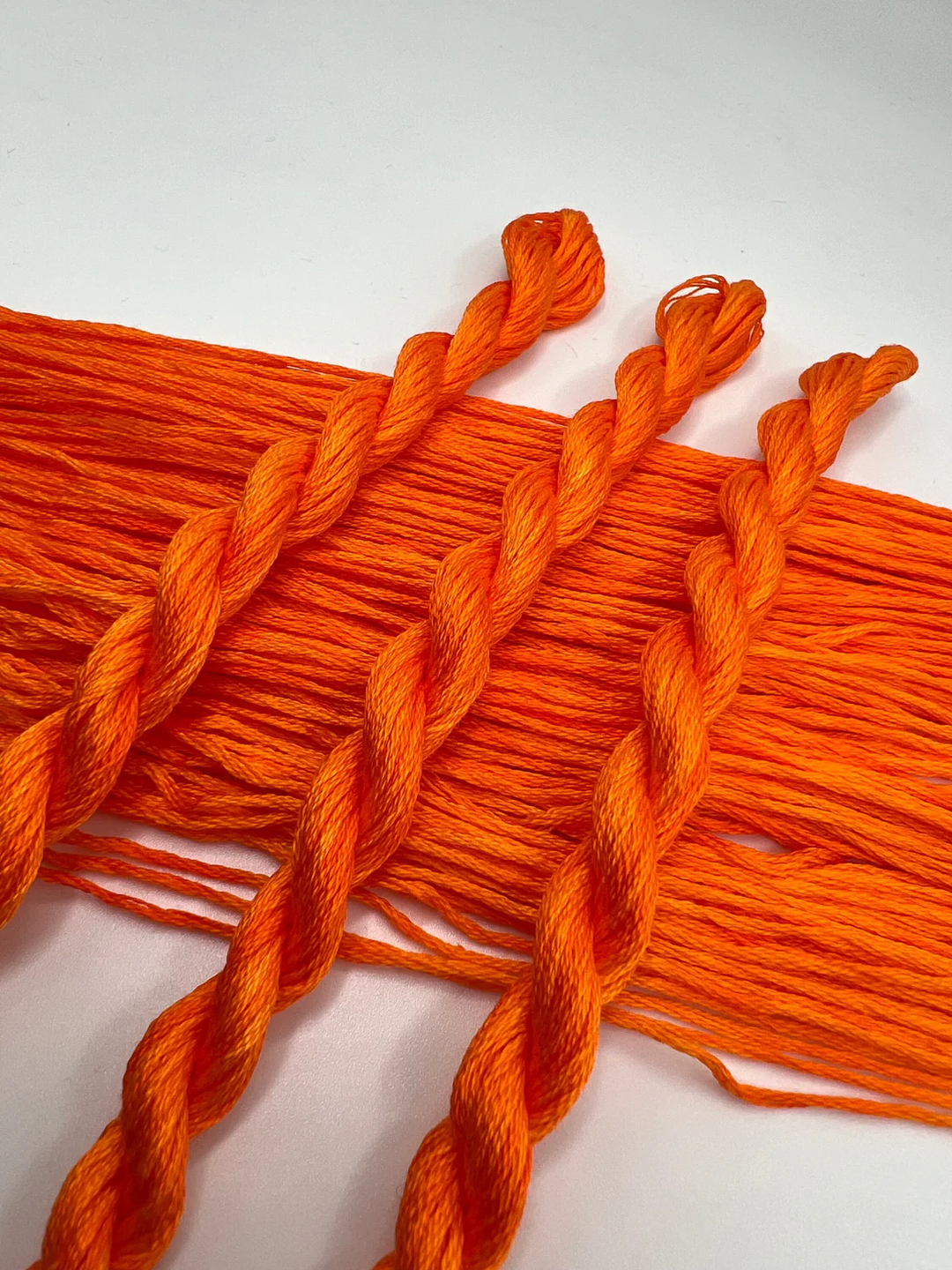 Orange embroidery floss on a white background