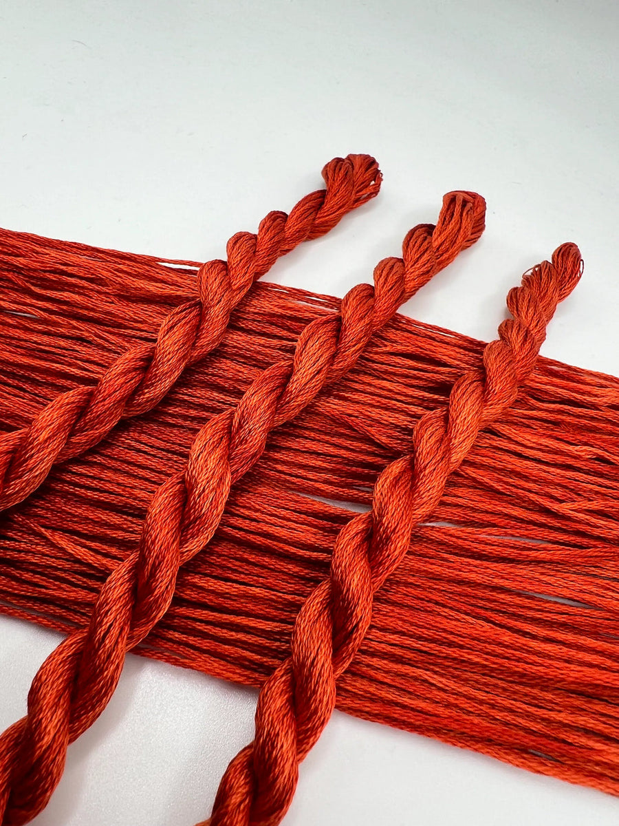 Red braided yarn on a white background
