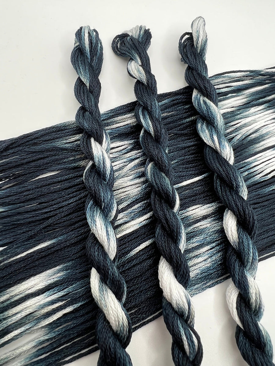 Three braided floss skeins in black and gray on a white background