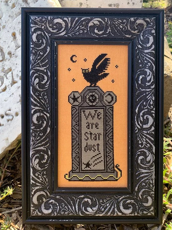 Decorative framed artwork with a black and white design on an orange background