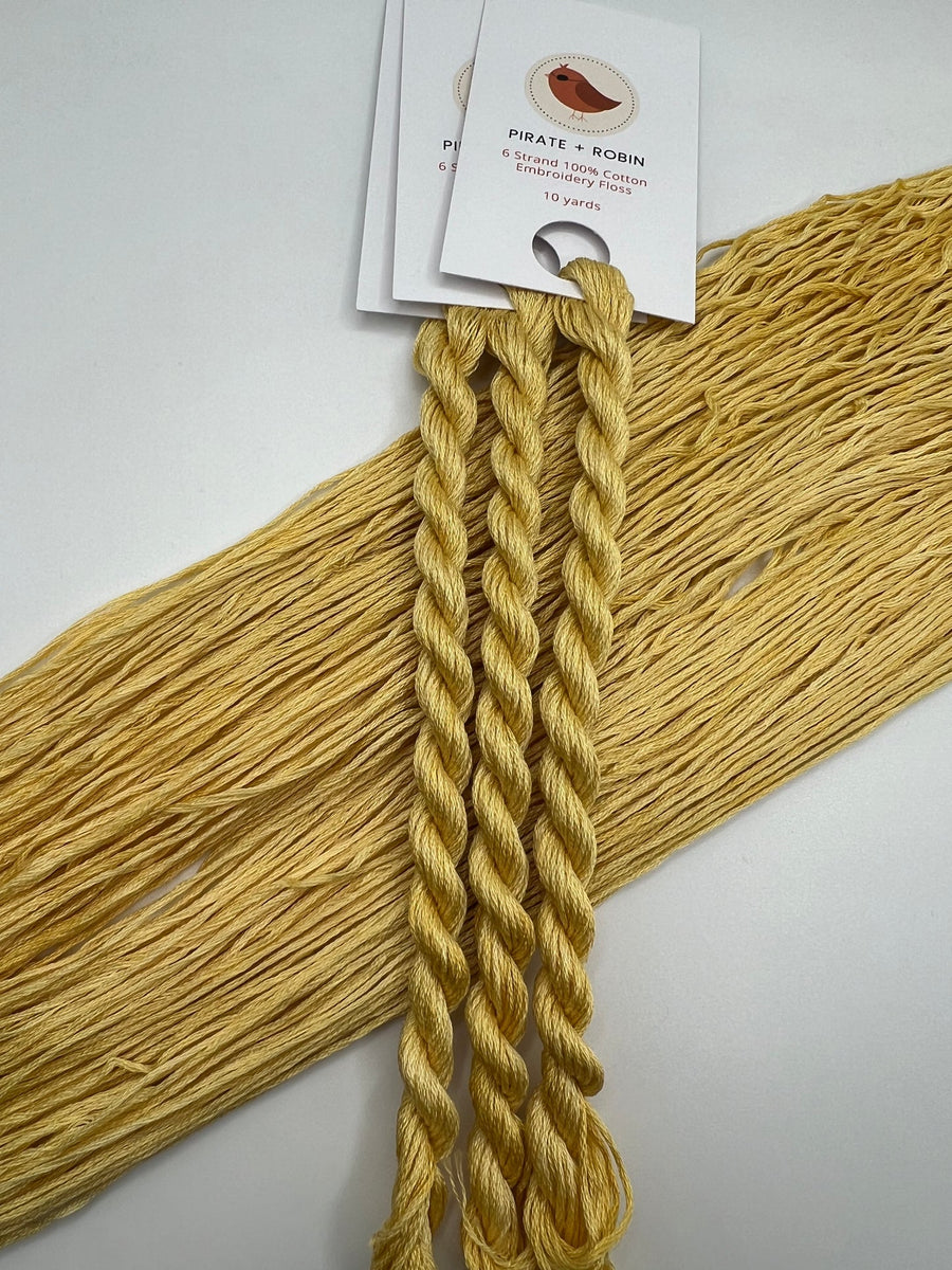 Yellow embroidery floss skeins with a tag on a white background