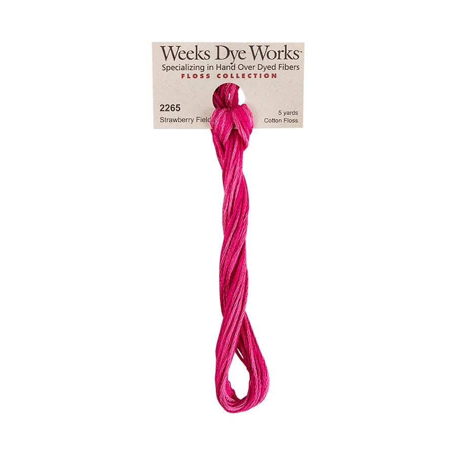 A skein of Weeks Dye Works Strawberry Fields cotton thread in a bright pink color, attached to a paper label card against a plain white background.