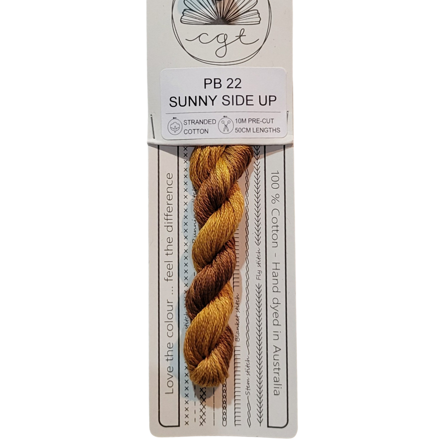 A skein of hand-dyed orange embroidery floss labeled 'Sunny Side Up' from Cottage Garden Threads.