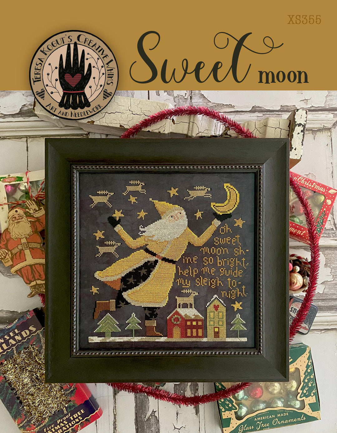 Framed cross-stitch art with a festive design, surrounded by holiday-themed decor.