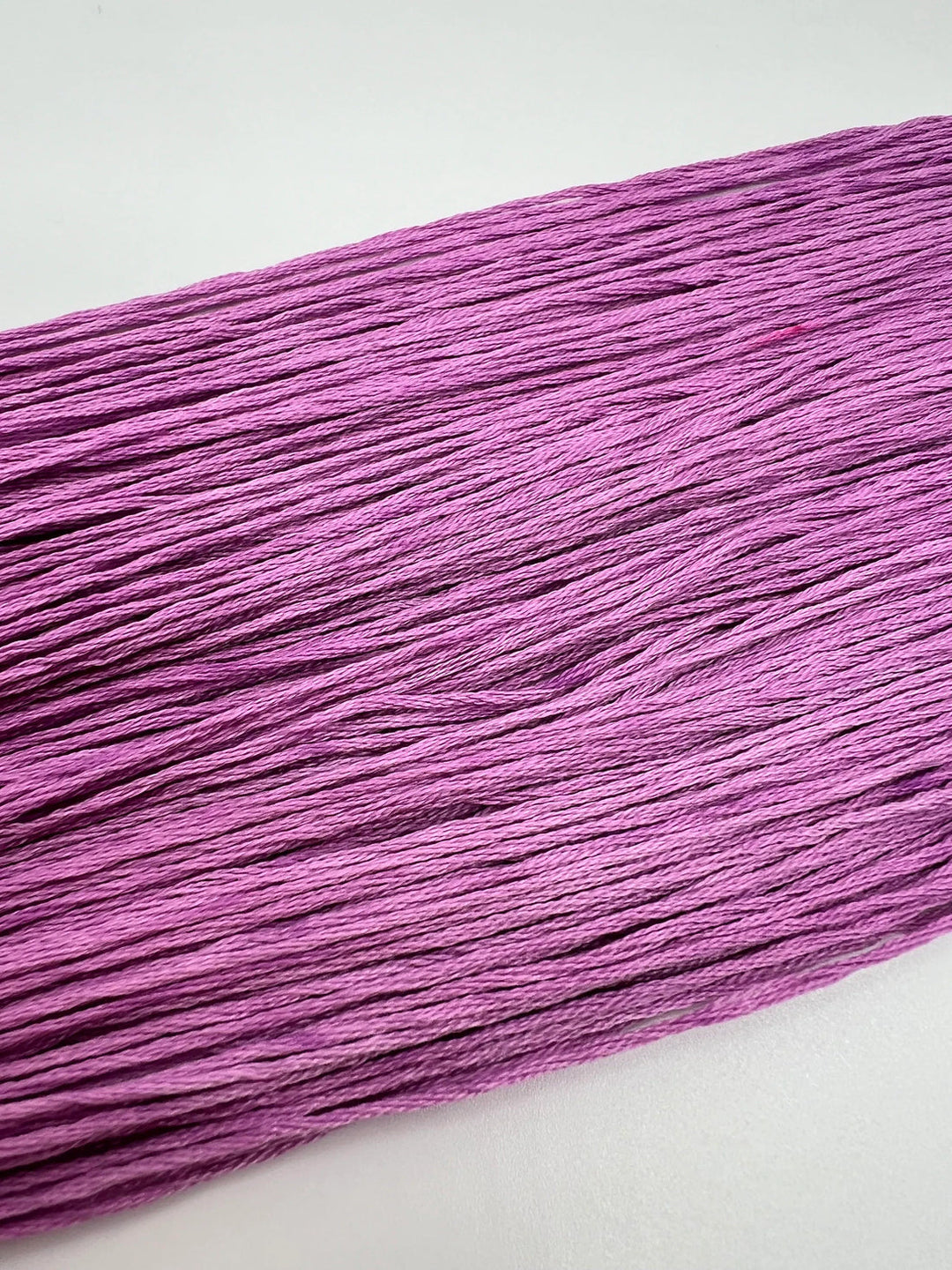 Close-up of purple thread on a white background