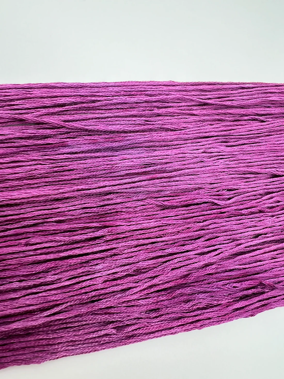 Close-up of purple embroidery floss  on a white background