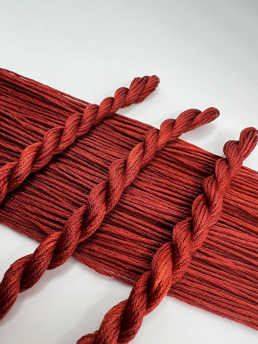 Red braided thread skeins on a white background