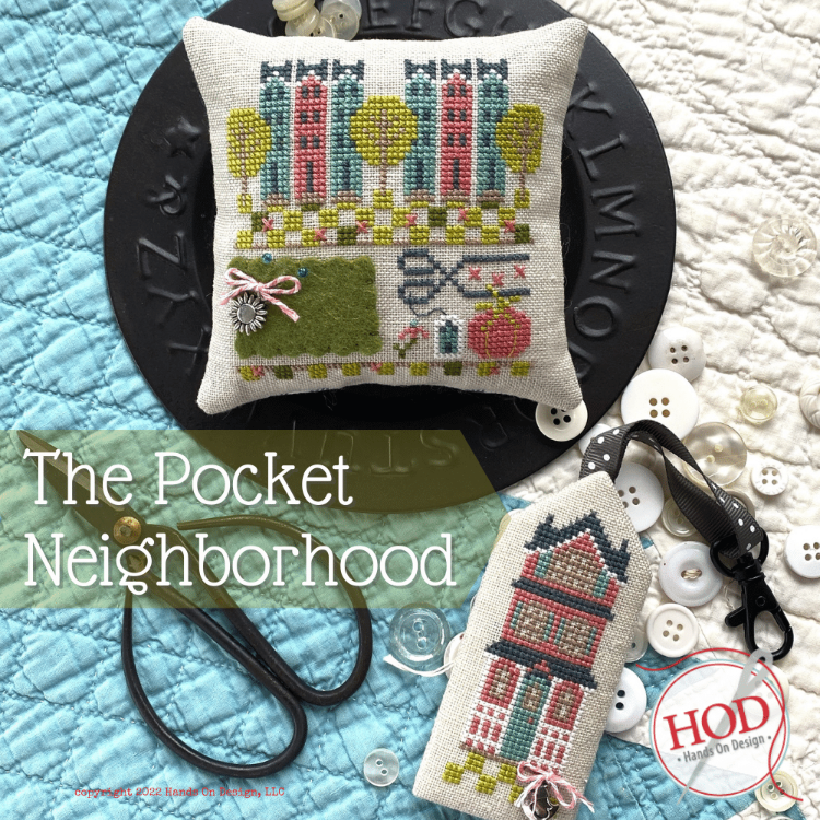 Cross-stitched pillows with 'The Pocket Neighborhood' text and HOD logo on a textured fabric background.