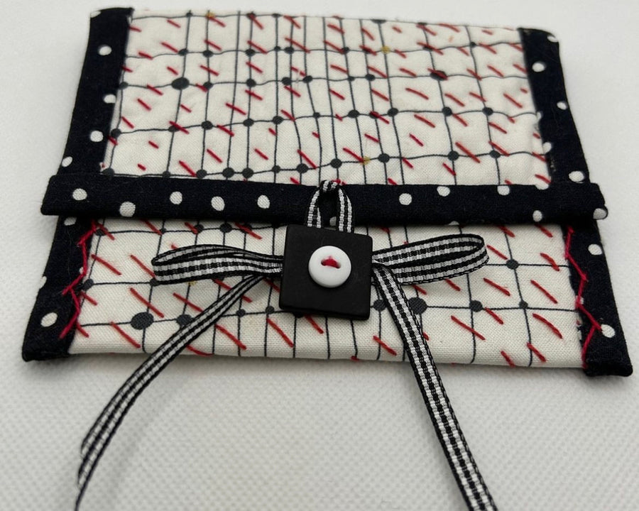 Fabric roll with black and white pattern and bow on a white background