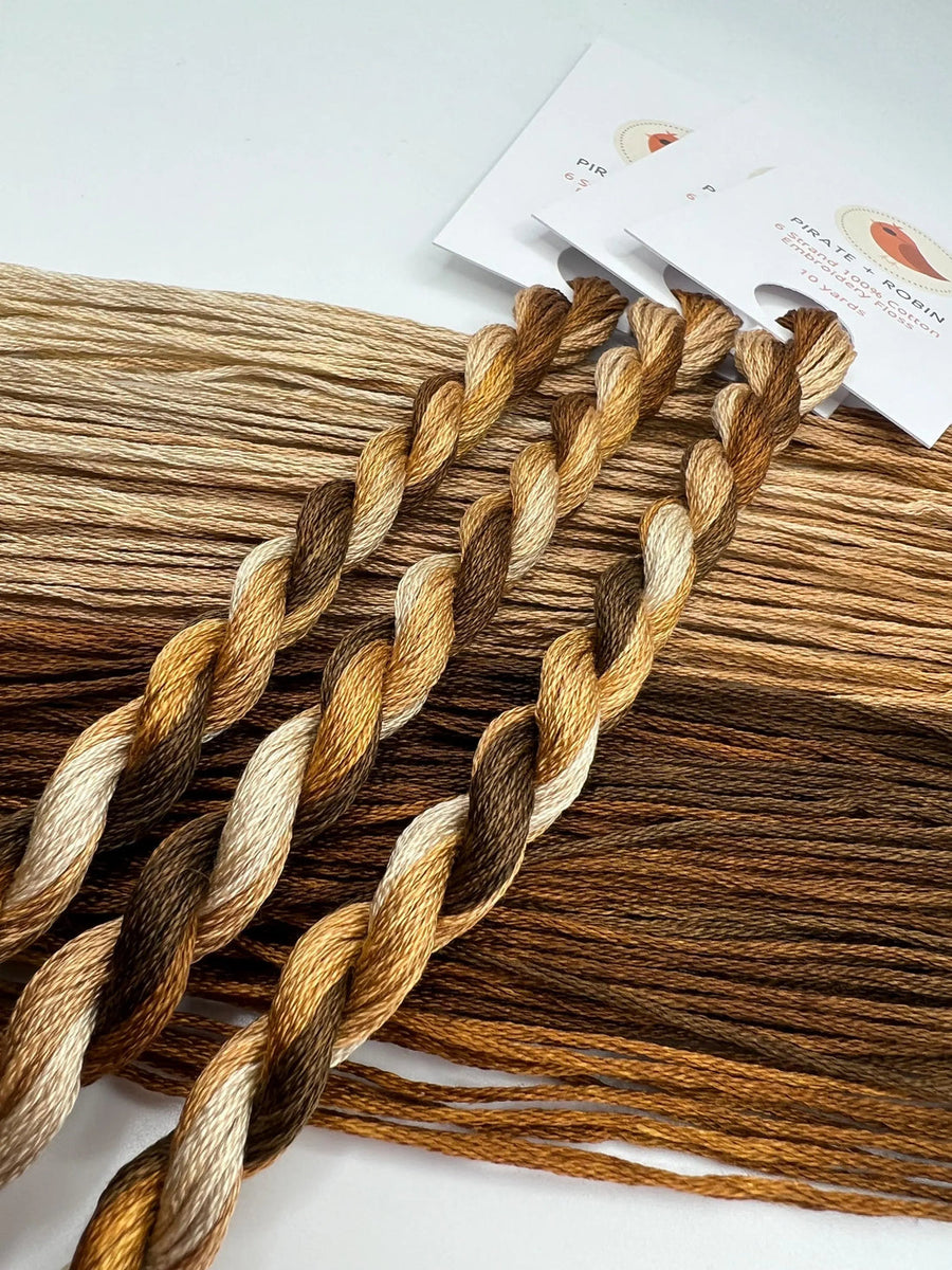 Braided  skeins of thread with various brown shades on a white background