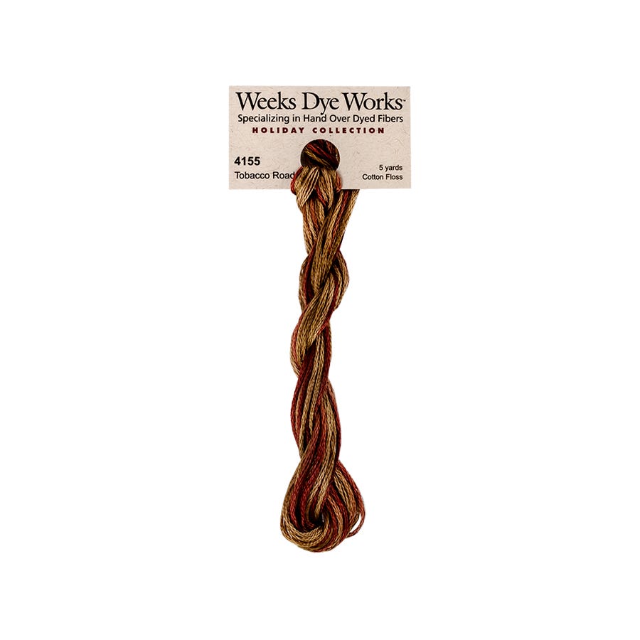 A single twisted bundle of Weeks Dye Works Holiday Collection embroidery floss in Tobacco Road, featuring a variegated pattern of brown, gold, and muted red threads, attached to its original paper header card against a plain white background.
