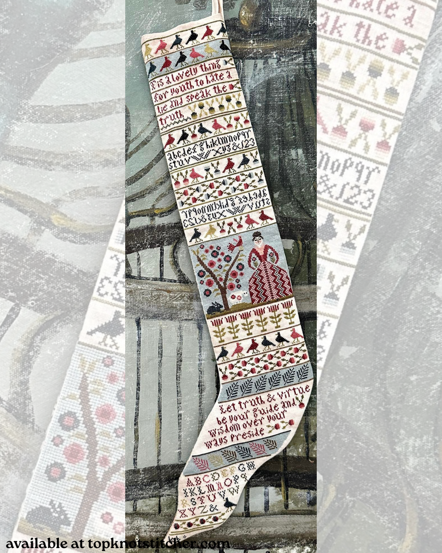 A vertical cross-stitch sampler stocking shown laid flat against a rustic wooden background, flanked by two close-up side panels of the sampler's pattern details. The sampler features embroidered text, geometric borders, floral motifs, and a central bird design in muted red, black, green, and cream tones.