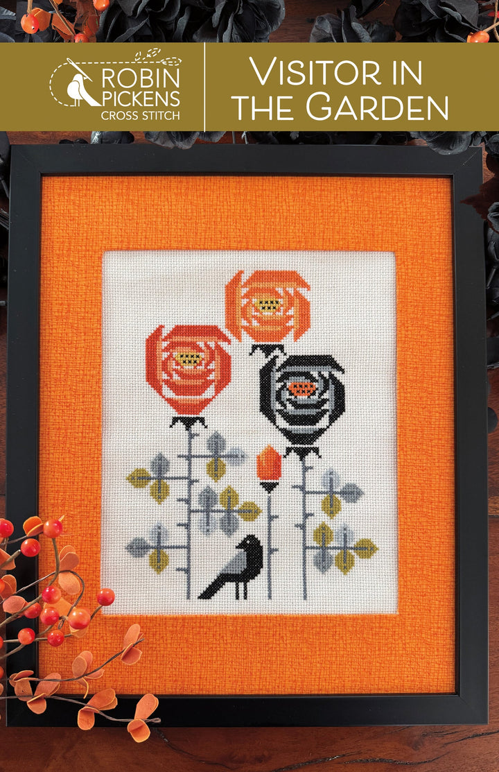 Framed cross-stitch pattern with flowers and a bird on an orange background, featuring Robin Pickens branding.
