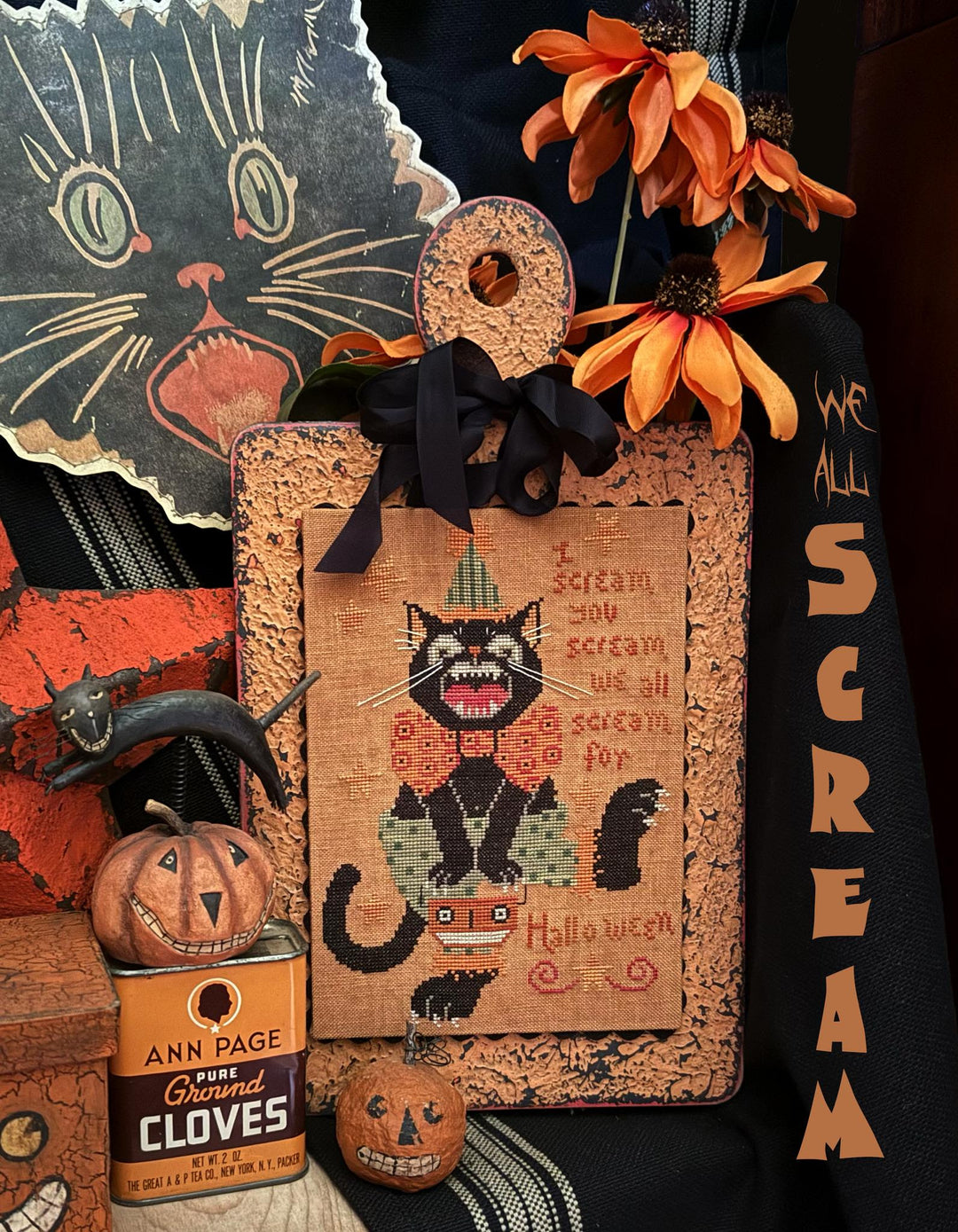 Halloween-themed decorative sign with black cat and pumpkins, surrounded by autumnal elements.