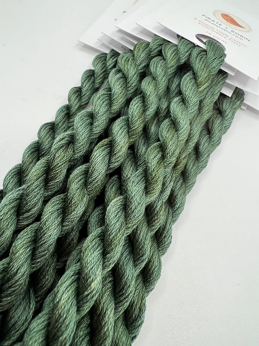 Green thread skeins on a white background