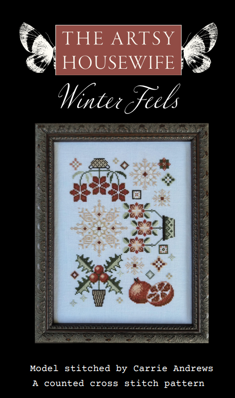 Cover art for 'Winter Feels' cross stitch pattern by The Artsy Housewife, featuring a framed sample stitched design with snowflakes, flowers, holly, and pomegranates on a black background.