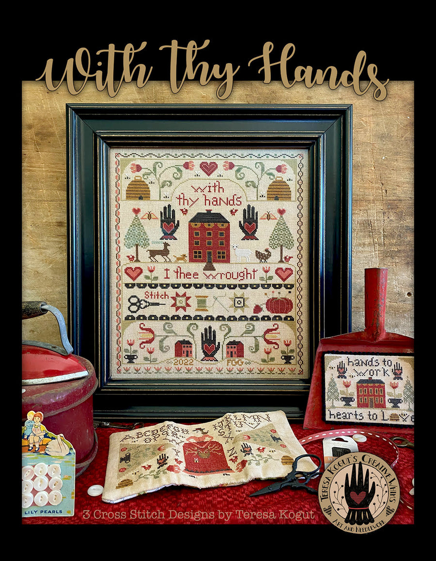 Framed cross-stitch pattern with decorative items on a wooden background