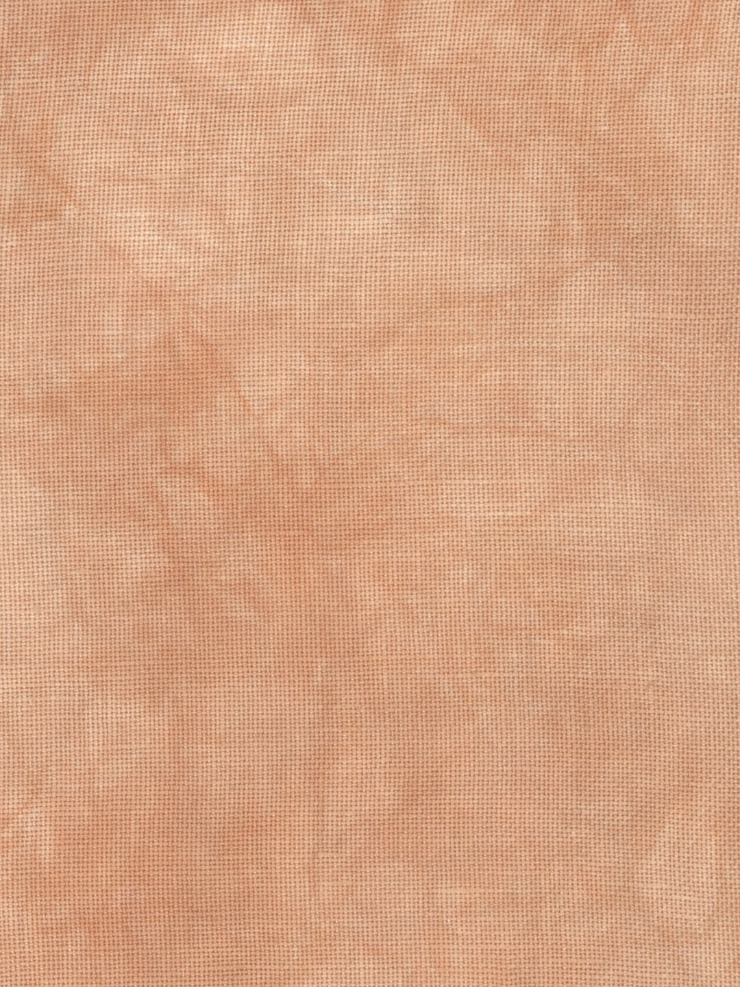 A close-up of a textured fabric or material swatch in a warm peachy beige color with subtle tonal variation.