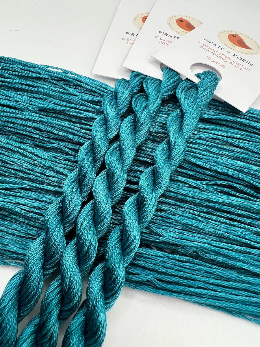 Turquoise skeins with brand labels on a white background