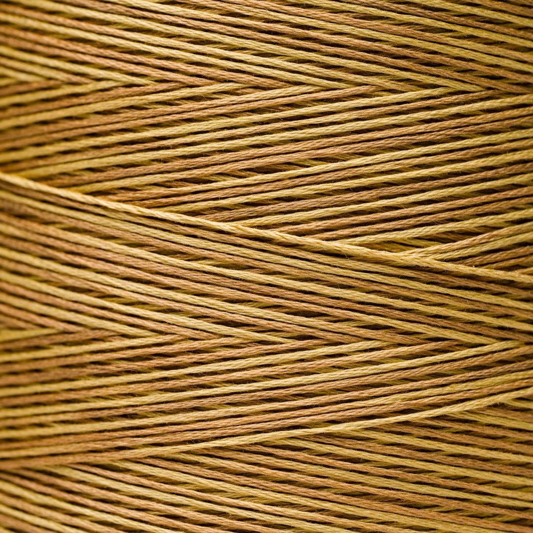 A close-up texture shot of braided embroidery thread in a warm tan and brown color.