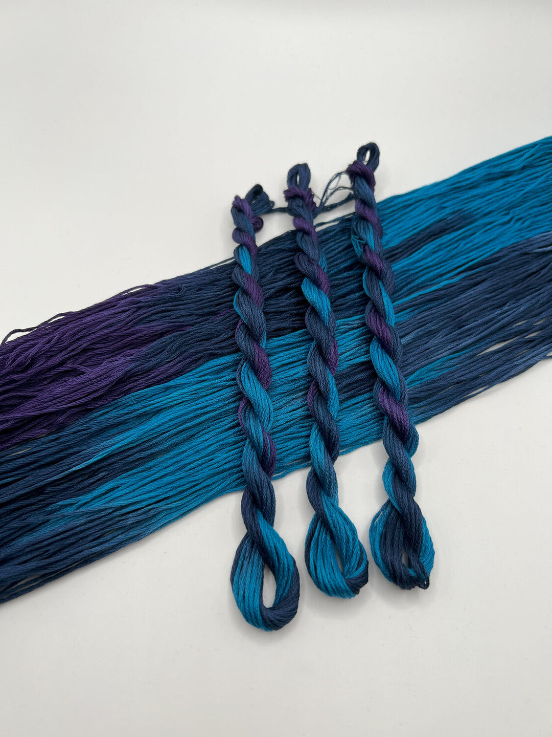 Blue and purple braided hair extensions on a white background
